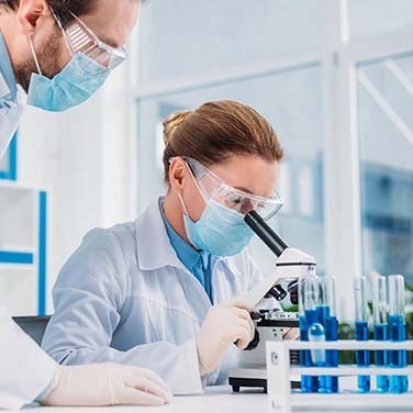 Des scientifiques regardant à travers un microscope